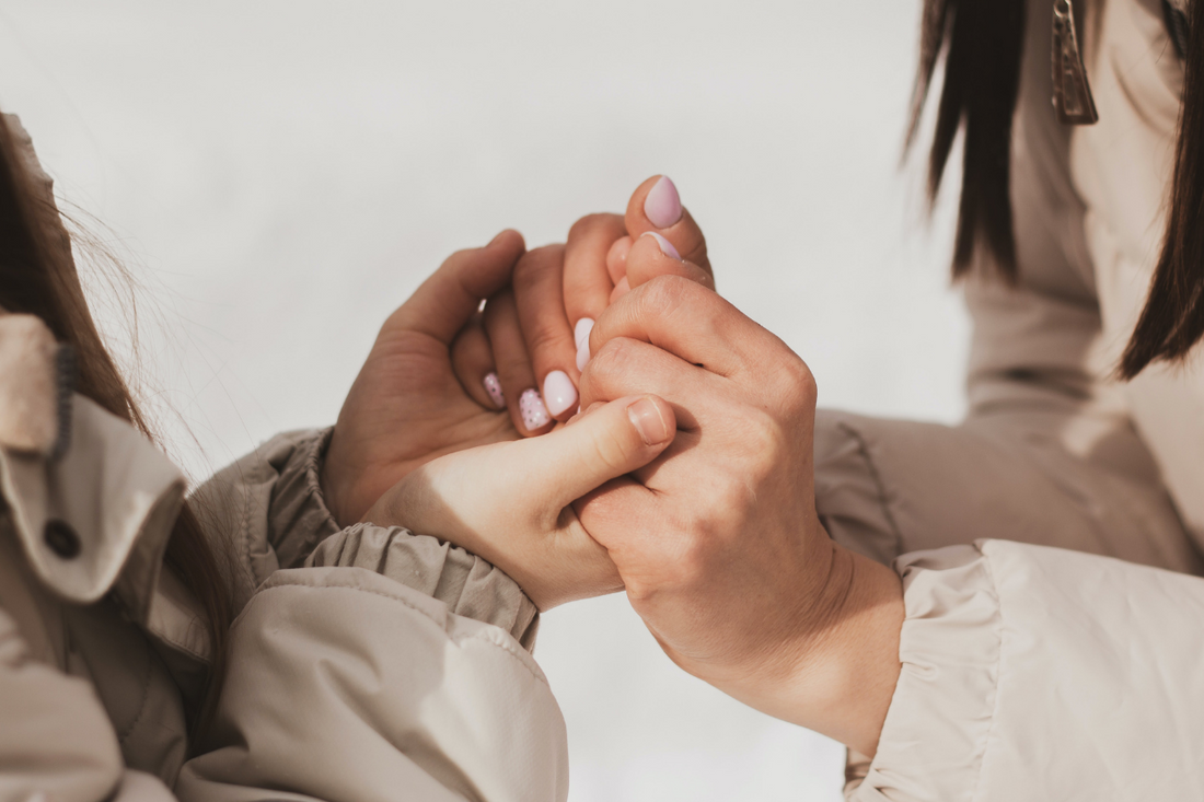 Two women holding hands.